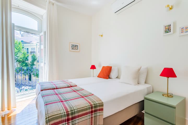 غرفة نوم بسرير فردي ومكيف هواء وشرفة