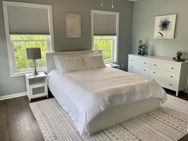 Our sunny queen room features 4 windows, a queen bed and a large 6 drawer dresser.