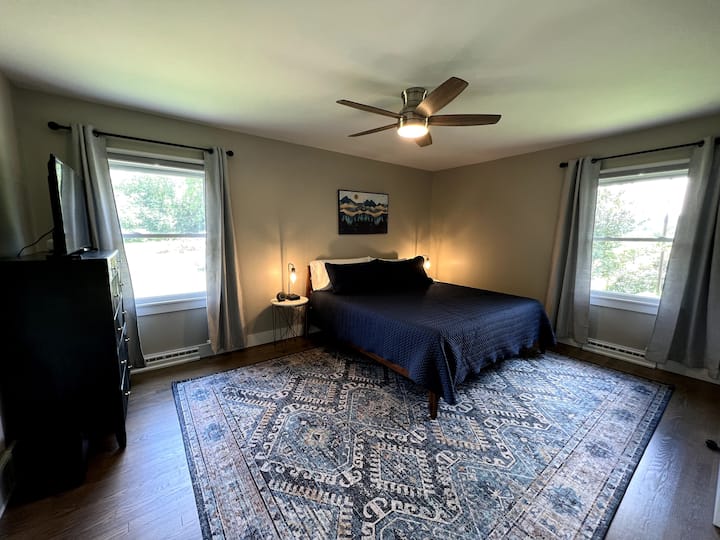 Primary bedroom with king bed, 40 in Smart TV, and private bathroom. Bedside tables have USB lamps for your convenience, as well as a sound machine.