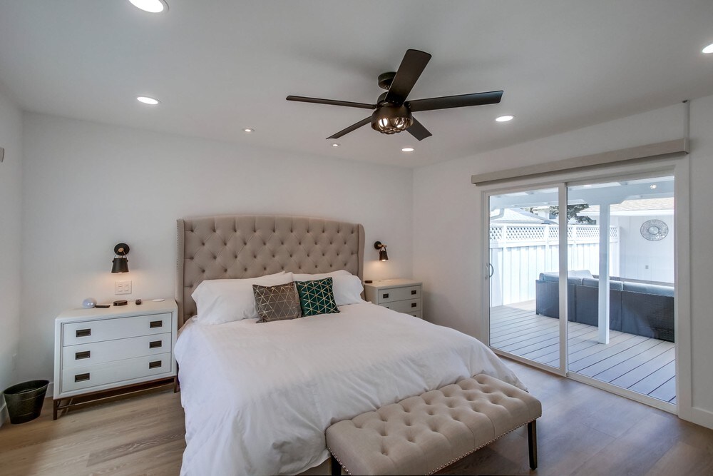 Главна спална соба со приклучена главна бања, 65-инчен паметен телевизор, клима уред, тавански вентилатор, директен пристап до терасата, брачен кревет (широк 150-179 см), паметен звучник Alexa и USB за полнење на секоја ноќна масичка.