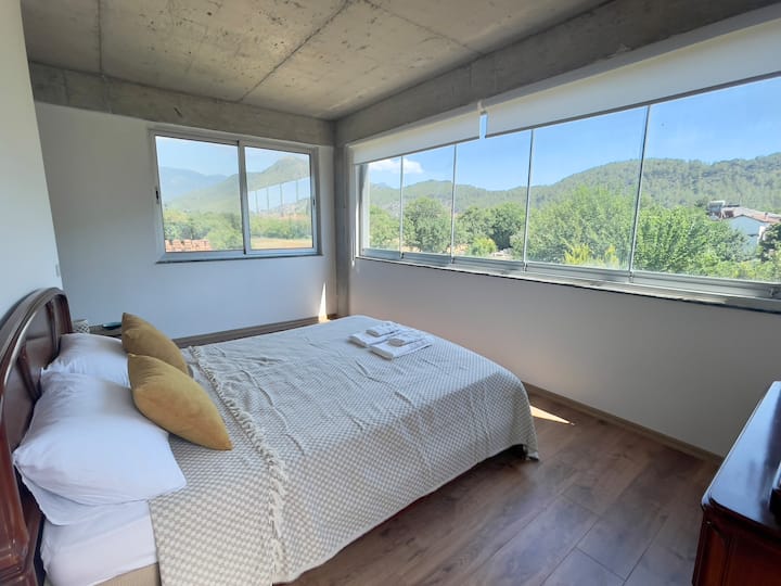 Chambre n °2 : chambre classique avec salle de bain privée et placard. Vue complète sur le jardin par la fenêtre et les montagnes environnantes. L'immense terrasse relie les BR #1 et #2.