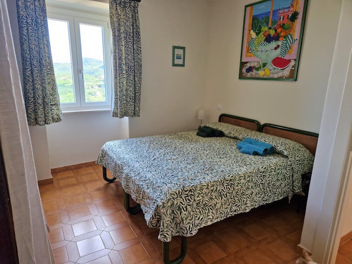 Ფართო ორადგილიანი საძინებელი გარდერობით, საგარდერობო ოთახით, სარკითა და გვერდითა მაგიდებით.  Ლამაზი ხედი ხეობაზე პორტო-ვენერისკენ.