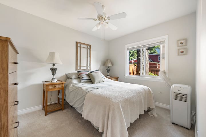 Master bd arm ina kitanda kizuri cha malkia na mtazamo wa eneo la nyuma ya nyumba ya kula.