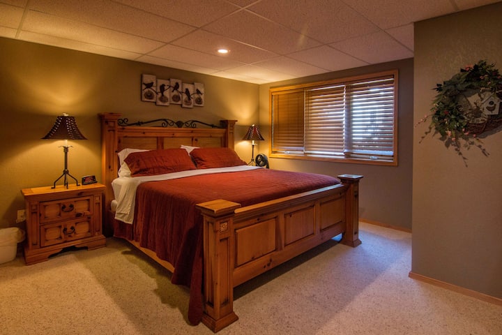 Basement bedroom with a king bed and 55" TV with Direct TV and Disney+.