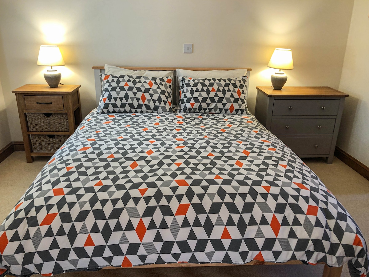 Dhomë gjumi en-suite me pamje nga laguna e Somerfordit.  Ka një krevat me përmasa mbretërore me shumë hapësirë të varur dhe sirtar.