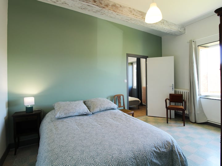 Chumba cha kulala chenye vitanda viwili na mashuka laini yenye ruwaza ambayo hufanya chumba kiwe cha starehe