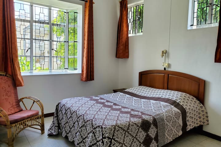 Spacious second bedroom, equipped with fan and air conditioning - overlooking beautiful garden