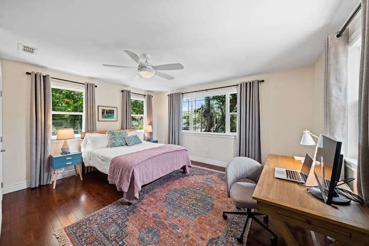 Bedroom 2, a spacious queen bed room with tree-view windows and another workspace — perfect for remote workers or families exploring the Texas Hill Country from this Kerrville vacation rental.