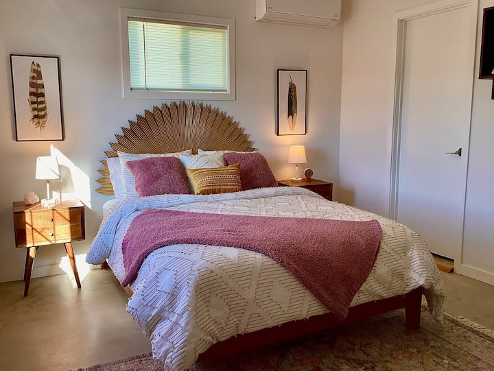 Beautiful light filled back bedroom with views of the desert and a Joshua Tree. Queen bed, side tables, dresser and open closet.  Dedicated A/C in room.