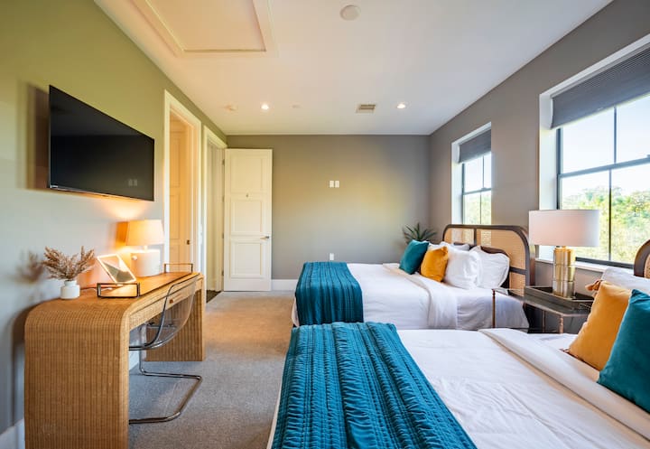 חדר שינה גדול מספר 4 עם מיטות קווין סייז תואמות, טלוויזיה עם מסך שטוח וחדר אמבטיה צמוד. 