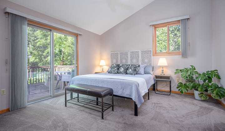 The primary bedroom hosts a king bed and a desk for  when needed. The desk can double as a vanity for hair and makeup needs as a mirror is provided. Enjoy your morning coffee on the deck just through the sliding doors. Ceiling fan overhead. 