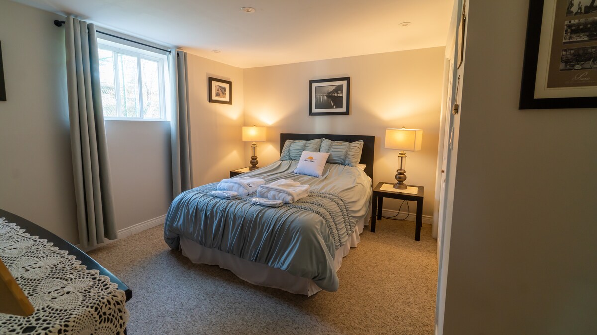 ห้องนอนใหญ่ที่เรียบหรูมาพร้อมกับรองเท้าแตะที่สบายและเสื้อคลุมอาบน้ำที่นุ่มฟู 