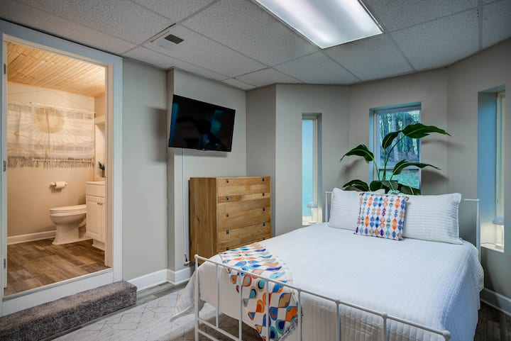 The 1st floor queen bedroom includes an attached full bathroom, kitchenette, smart TV, dresser, and a wardrobe closet in the bathroom. The shower head detaches for a handheld option making it easier for the kiddos. 