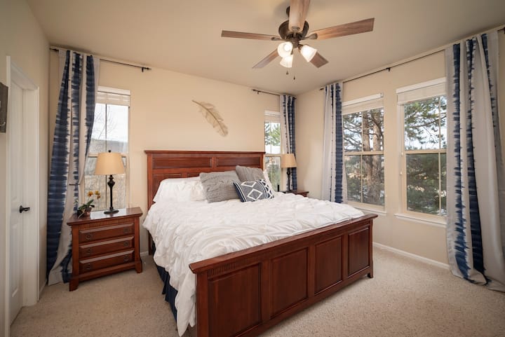 חדר שינה ראשי בקומה הראשית עם מיטת קינג סייז, מאוורר תקרה ווילונות האפלה