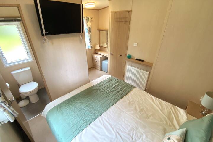 Двойна спалня с телевизор и самостоятелна тоалетна. Тоалет и гардероби.