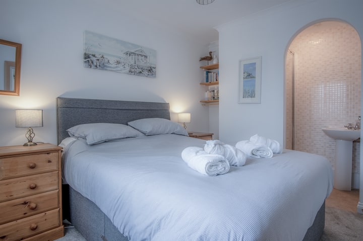 חדר שינה ראשי עם מיטת קינג סייז נוחה, כיור ומקלחת נוספים הממוקמים בחדר