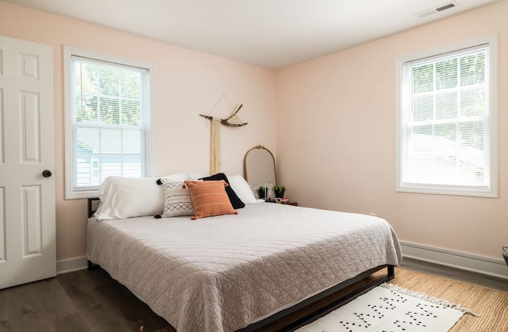 The third bedroom, or master suite, has a king sized bed with a luxury Nuform  mattress and high thread count cotton sheets. A nightstand to the right has a lamp for reading at night and a large mirror. 