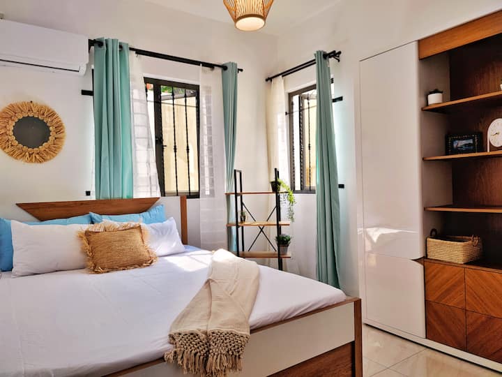 Das zweite Schlafzimmer (Option 2 - Zimmer im verträumten Stil) verfügt über ein Doppelbett mit einem Nachttischregal und einen beigefarbenen Kleiderschrank.