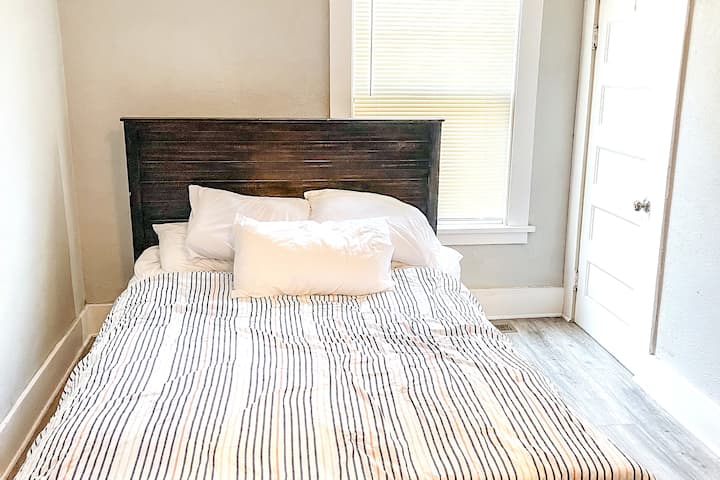 El dormitorio 1 cuenta con una cómoda cama de tamaño queen con mesa auxiliar y lámpara. Esta habitación está más cerca de la sala. Tranquilo, limpio y proporcionará a los huéspedes todo lo que necesitan. También tiene un armario para tu ropa o para guardar esa maleta. 