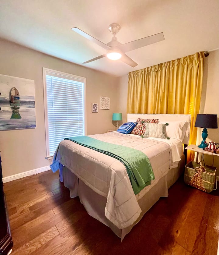 ห้องนอนที่อบอุ่นพร้อมเตียงควีนไซส์ที่สะดวกสบายและบรรยากาศที่มีสีสัน