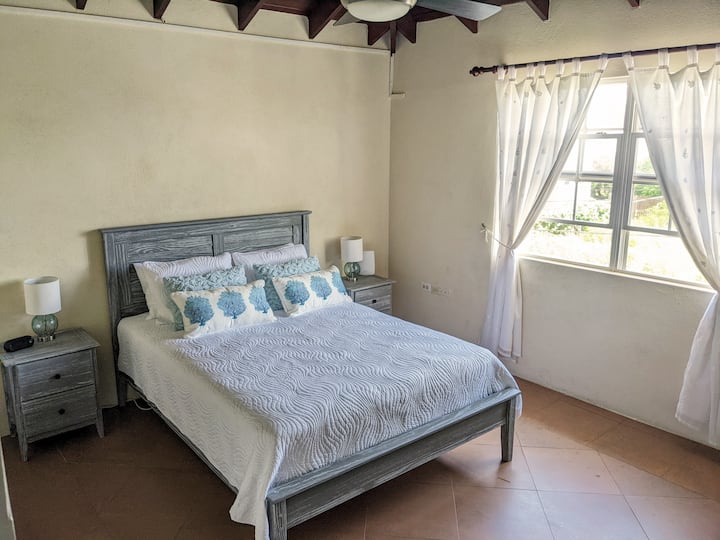 Krevat "Queen Size" në dhomën e gjumit en-suite. Të gjitha dhomat e gjumit kanë ventilatorë tavani dhe kondicionerë.