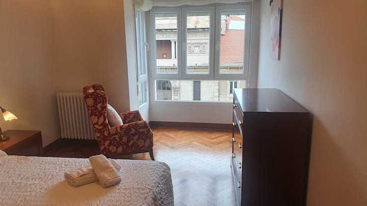 Habitación principal de la vivienda, con más de 16 m2, con cama matrimonial, buenas vistas al Teatro Jovellanos y Paseo de Begoña-