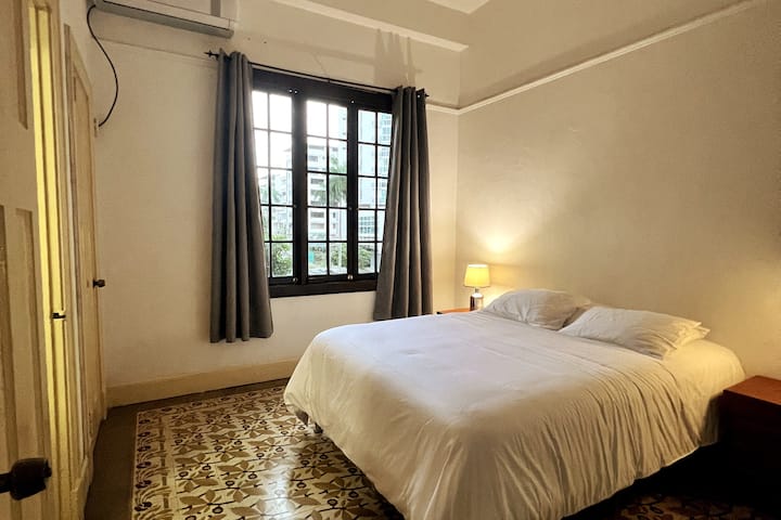 El dormitorio principal tiene una cama tamaño queen con un edredón mullido y aire acondicionado para cuando hace un poco de calor.