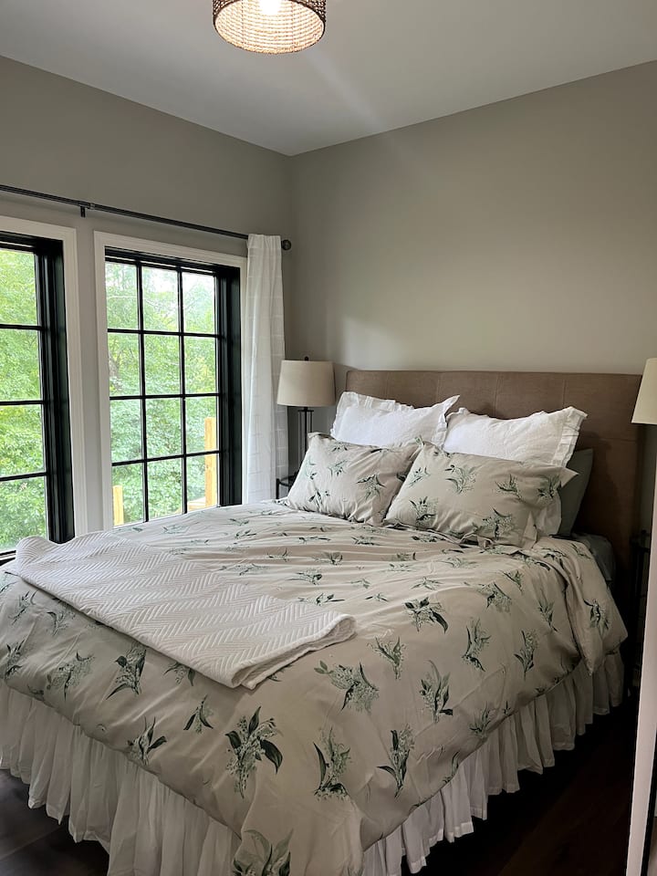 توجد الرفاهية في غرفة النوم الرئيسية هذه. استرخِ مع فراش مونيك لويير واستيقظ على إطلالات على البحيرة. 