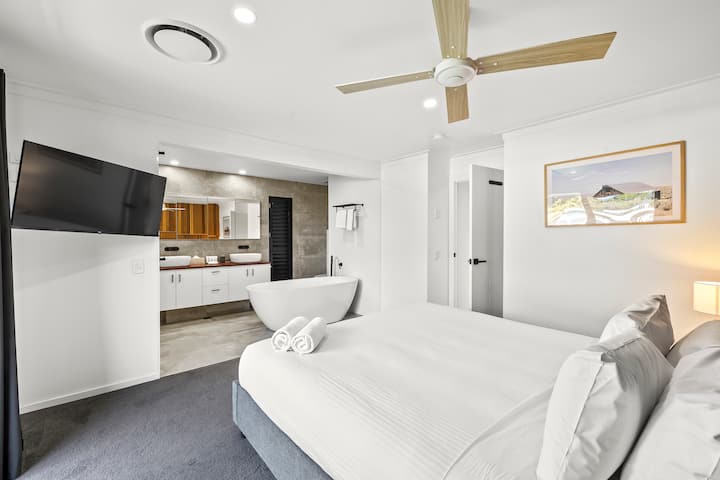 Master Bedroom with Open Modern bathroom. 
Bathroom with his&her sink&shower. 
With TV and aircon.
King bed with walk-in wardrobe. 
Access to the front garden and access to Deck (perfect for a cuppa in the morning).