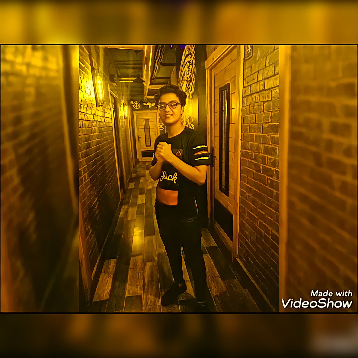 A narrow hallway features warm lighting and wooden flooring. The walls are decorated with patterned panels, creating a cozy atmosphere. Doorways are visible on either side, leading to private spaces. A figure stands at the center, partially obscured, adding to the sense of intimacy.