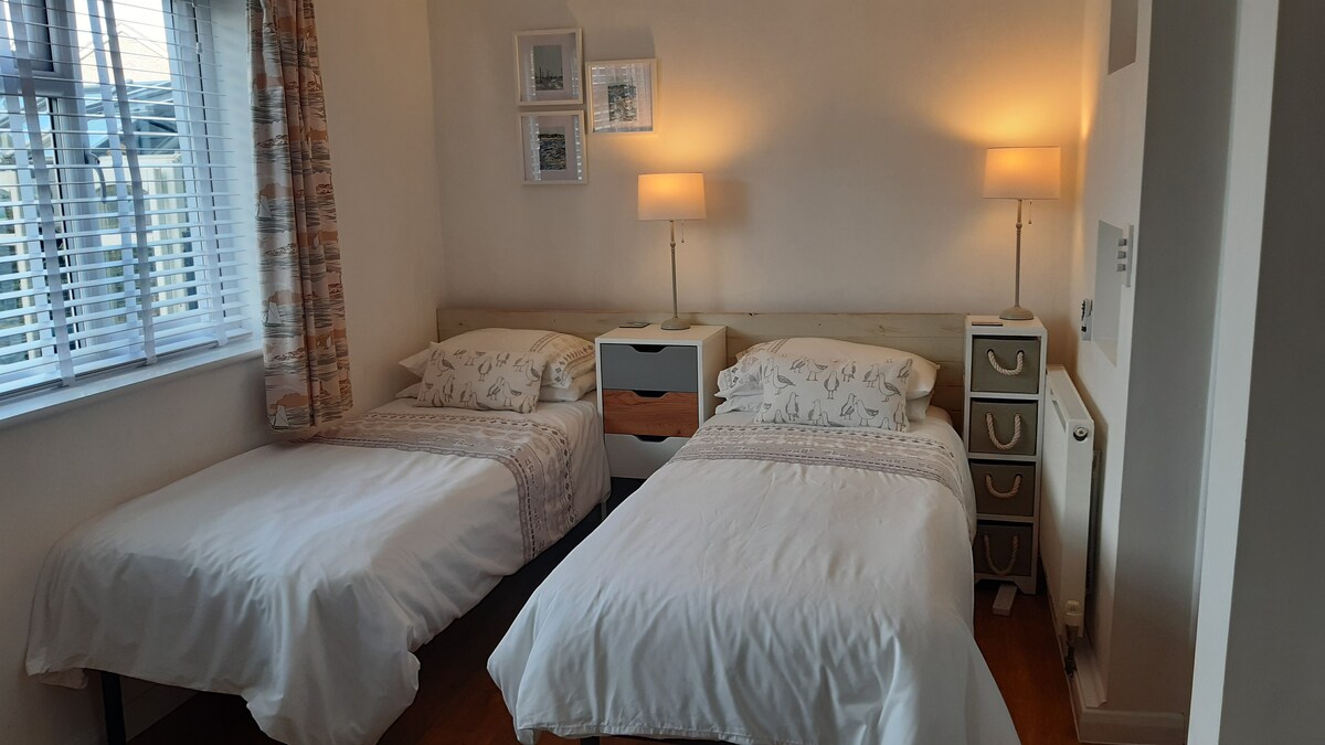 Chumba cha kulala cha nyuma kilicho na ukubwa wa kifalme au vitanda vya mtu mmoja kama inavyohitajika.