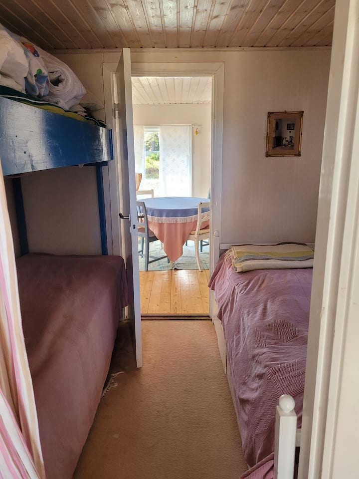 Një nga dy dhomat e gjumit në Lilla House, dhoma e dytë e gjumit ndodhet në lidhje të drejtpërdrejtë. Dhoma e ndenjjes në Shtëpinë e Vogël në sfond.
