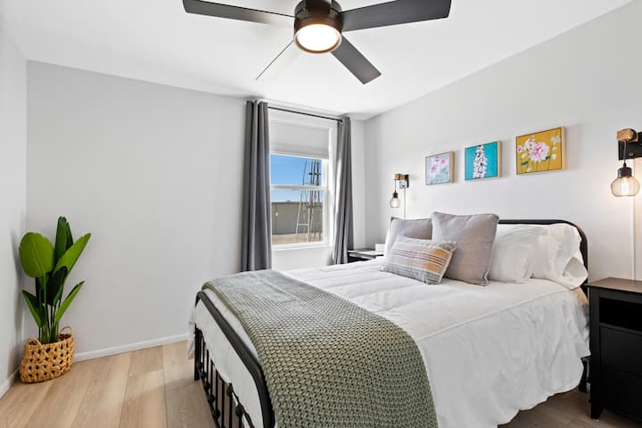 Bedroom 3 of 3 - Queen bed with ceiling fan, blackout curtains and closet.  All bedrooms have a closet with hangers, an alarm clock, folding luggage racks and charging cables.