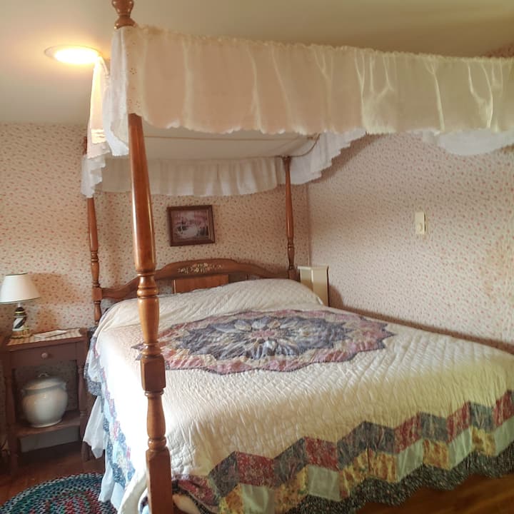 Dormitorio medio con cama doble con dosel.  Hay un armario en esta habitación también con almohadas y mantas adicionales. Todas las habitaciones tienen aire acondicionado en verano.