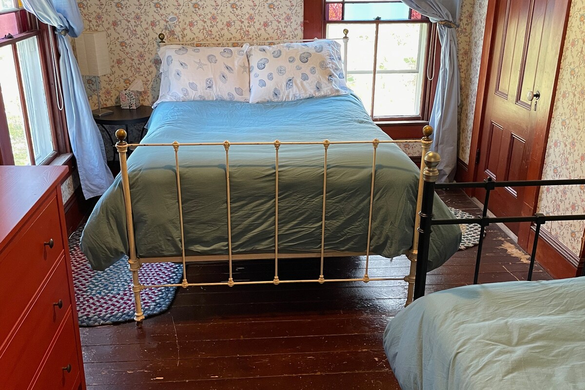 In de 3e slaapkamer, met uitzicht op het noordoosten, een tweepersoonsbed plus een eenpersoonsbed (of een ligbed om te loungen) - en twee glas-in-loodramen. 