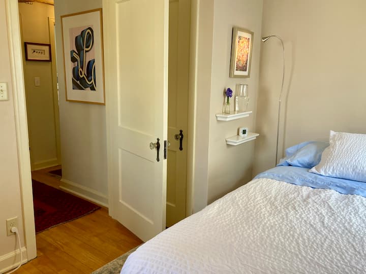 Bedroom #2: Small room with luggage rack, closet, desk, and two windows.