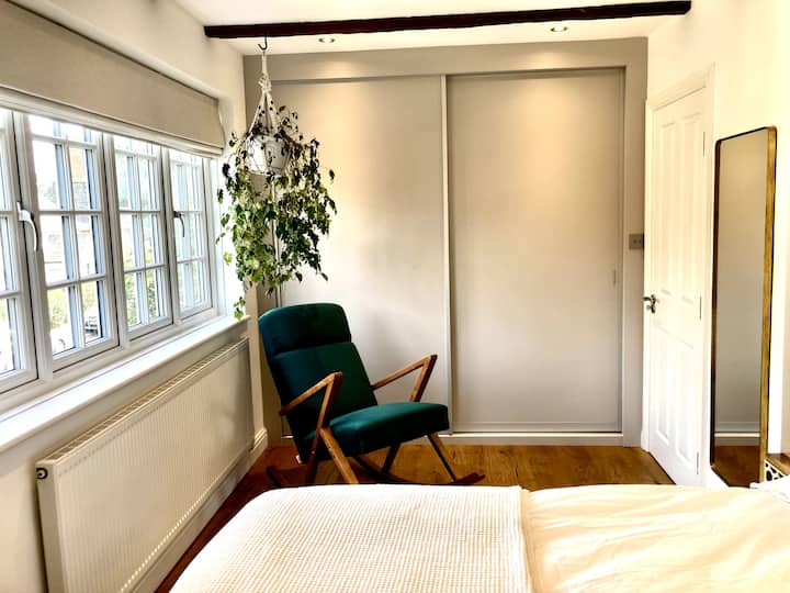 Dormitorio principal con cama de dos plazas y lujosas sábanas de algodón egipcio de la empresa blanca. Siéntate y lee un libro en la mecedora. Guarda la ropa en el armario con espacio para colgar y cajones. 