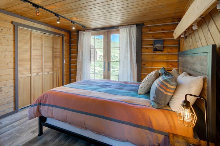 The main floor bedroom has a queen bed and French doors to the wrap around deck. 