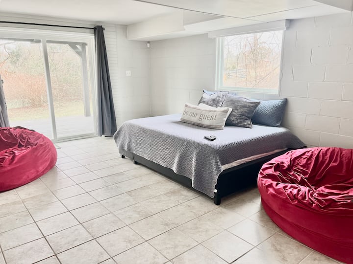 ห้องนั่งเล่นใต้ดินมีทีวีบนผนังและทำหน้าที่เป็นห้องนอนที่ 5 ในบ้านพร้อมเตียงคิงไซส์ 