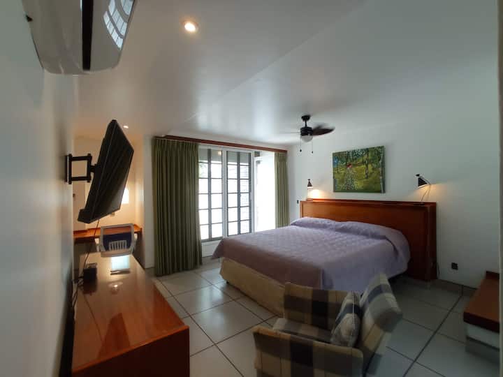 חדר שינה 2 עם מיטת קינג סייז, טלוויזיה חכמה, חדר רחצה ושירותים ומרפסת המשקיפים על מגרש הגולף.