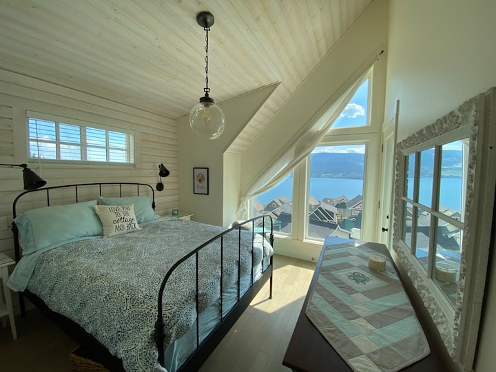 Second story master bedroom with vaulted ceiling and attached private deck with duo lounge chairs. Stargazing has never been better.