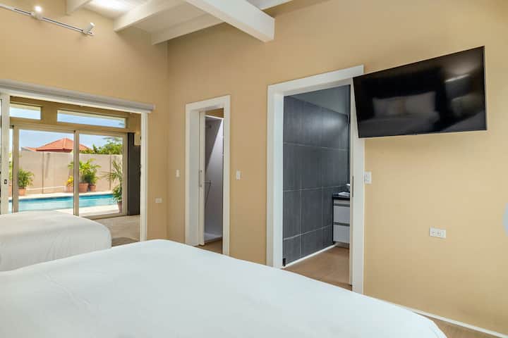 Il y a deux lits Queen Size dans cette chambre, une télévision, une salle de bain et un accès direct à la piscine.