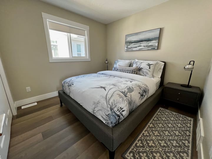 The second guest bedroom also features a queen-size Bloom brand mattress, a large closet, and premium bedding