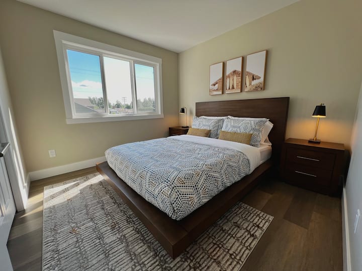 The first guest bedroom features a queen-size Bloom brand mattress, a large closet, and premium bedding
