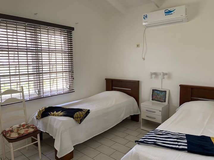 Chambre avec lits jumeaux avec une table de chevet et des lumières au milieu.
Cette chambre dispose également d'un placard intégré et d'une climatisation.