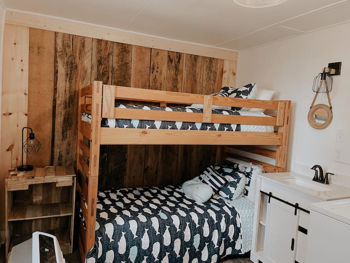 Samostojeća „kuća na kat” s bračnim krevetom na kat, smještena u istom prostoru kao i perilica i sušilica rublja te ima umivaonik.