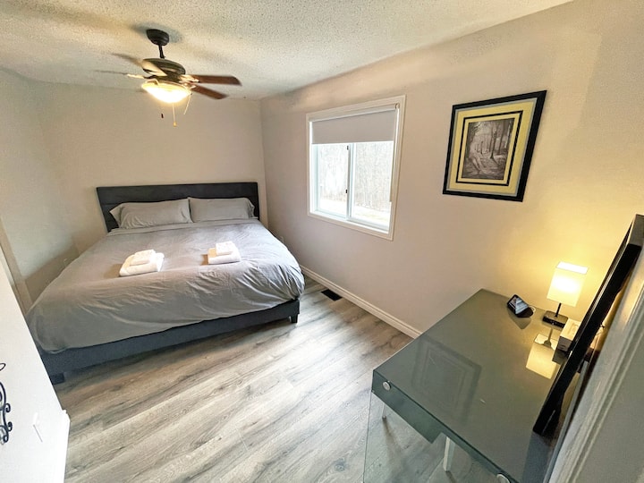 Unwind in this serene and cozy bedroom featuring a luxurious king-sized bed. The soft, neutral tones and modern decor create a peaceful atmosphere perfect for rest and relaxation.
