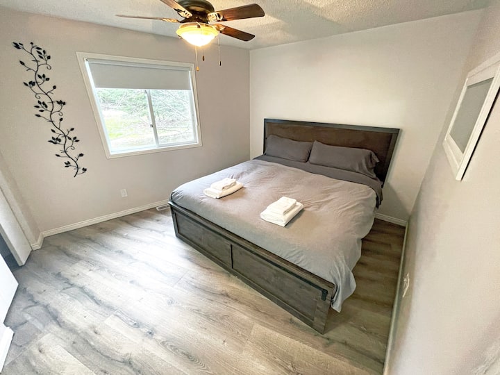 Retreat to comfort in our main floor bedroom, featuring a luxurious king-sized Tempur-Pedic bed. This serene space is designed for restful nights, complete with soft linens and peaceful surroundings.