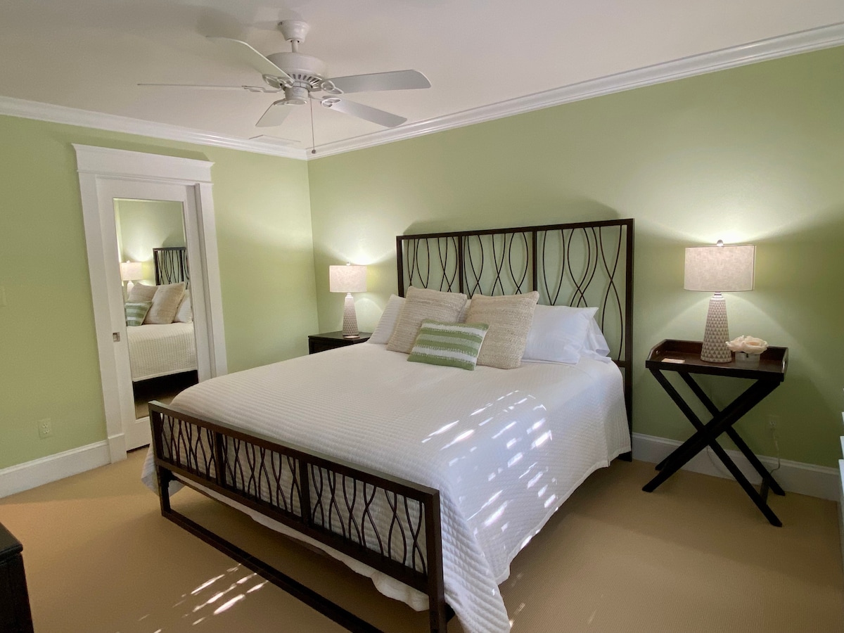 Chumba cha kulala cha wageni kilicho na kitanda cha mfalme na runinga.