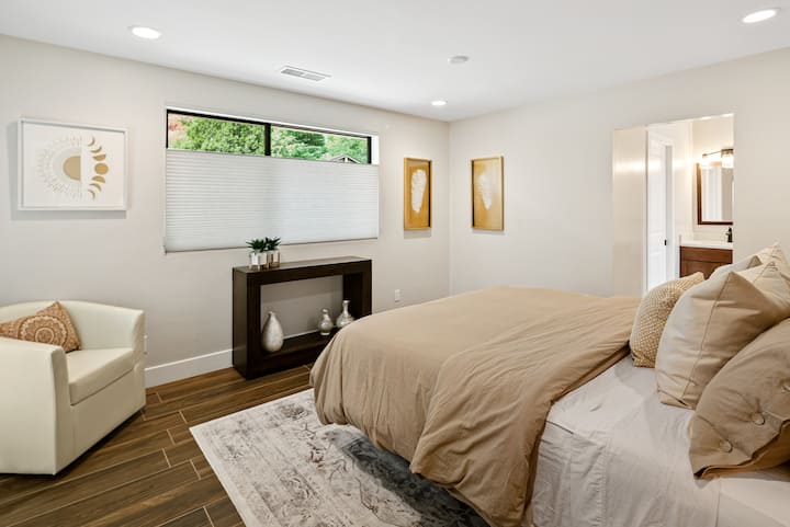 3rd bedroom with a king bed and private bathroom. Views the front yard.